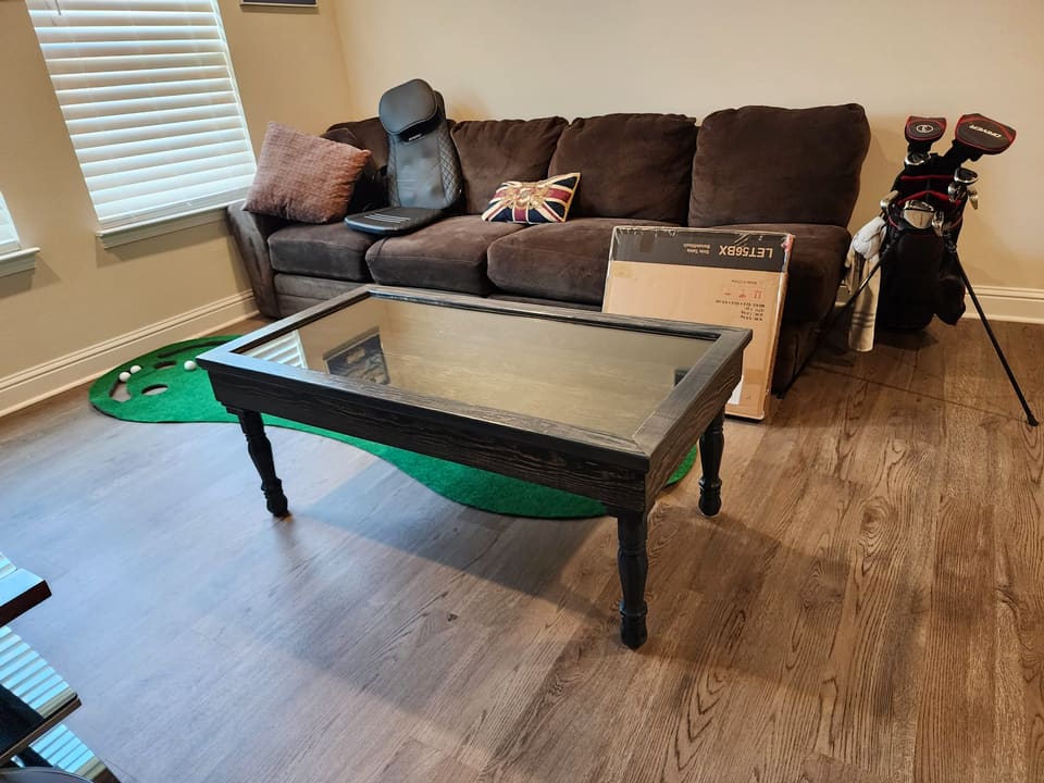 Blue shadow-box coffee table with a glass top in a living room