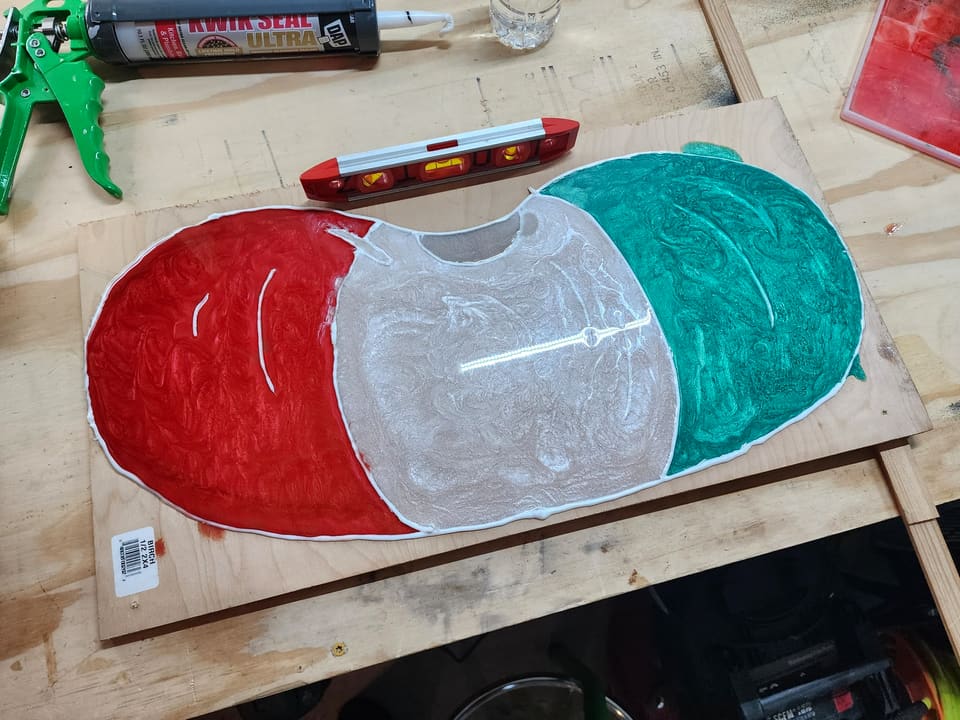 Watermelon slice mid-build with resin poured and a level across the top