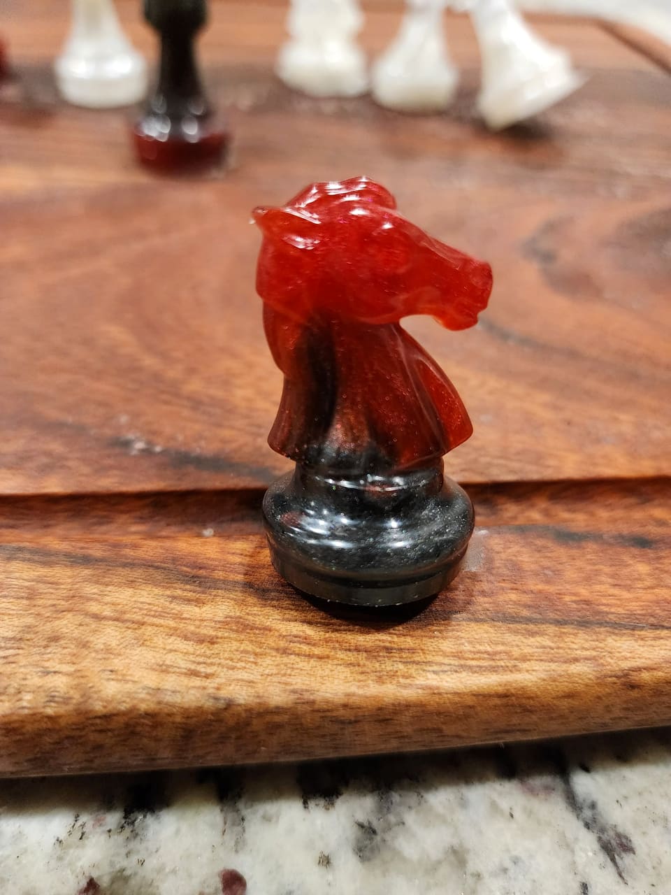 Deep red resin knight piece with a dark base