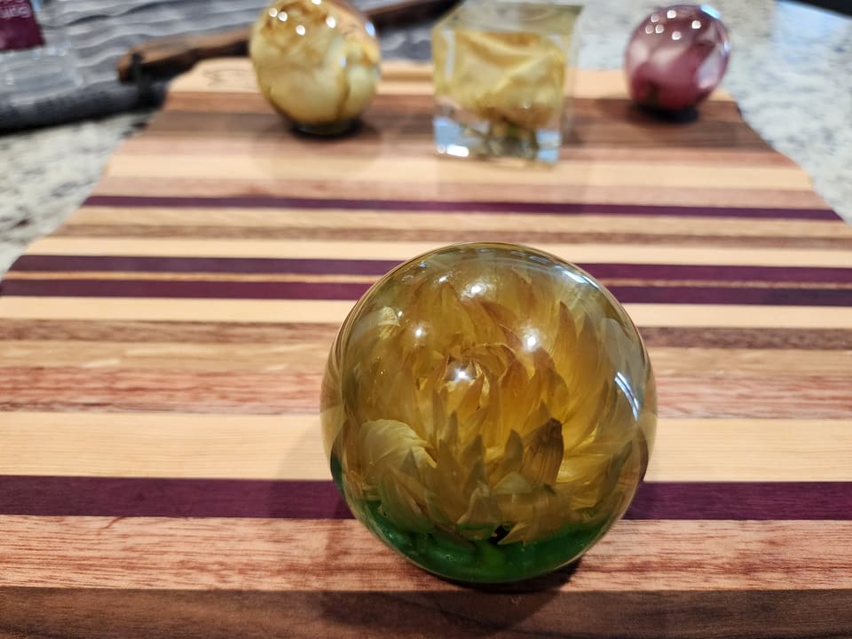 Amber-toned bloom in a resin sphere