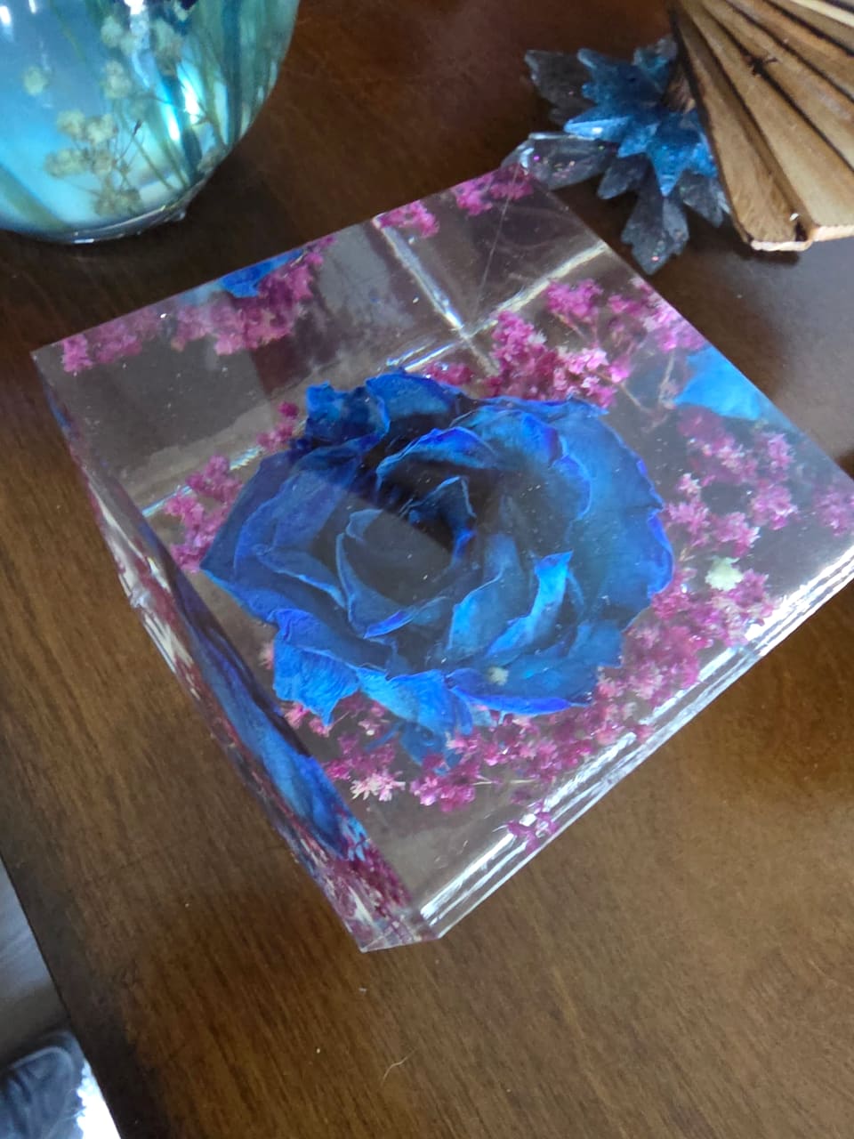 Blue rose with pink dried flowers set in a clear resin cube