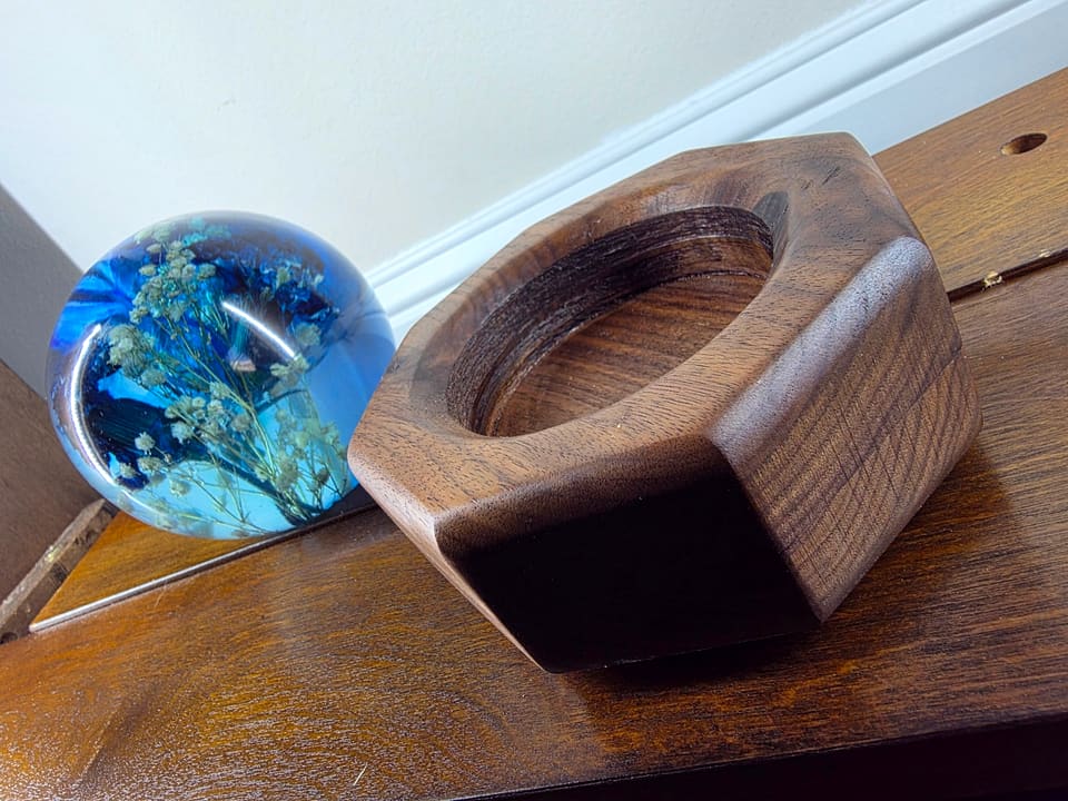 Resin sphere beside its hexagonal walnut base before assembly