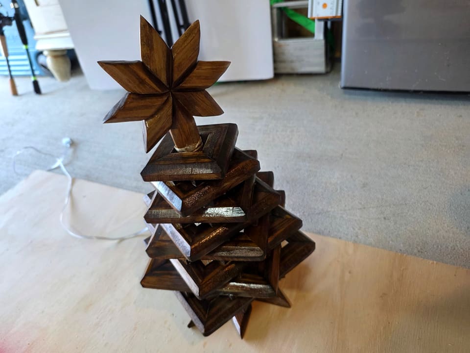 Stacked wood Christmas tree with a carved star on top, unlit