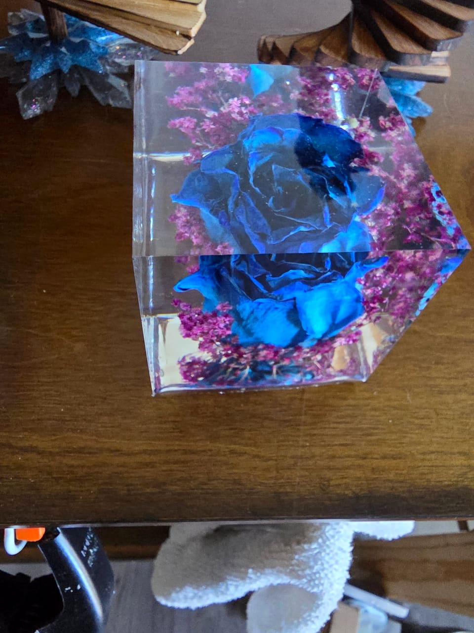 Close view of the resin cube showing the blue rose and magenta flowers through the clear sides