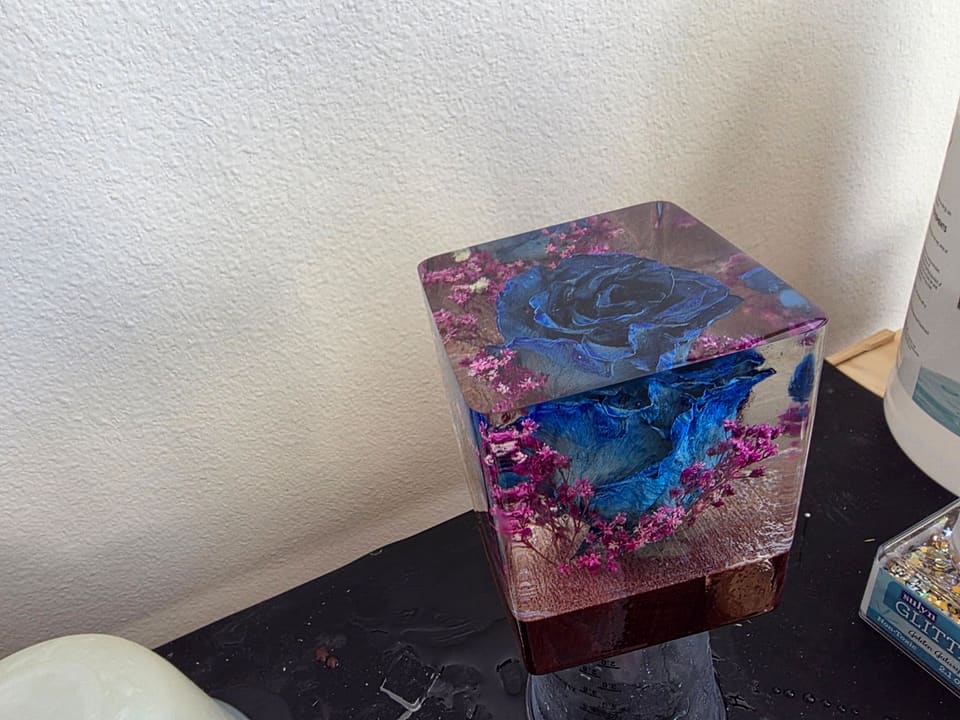 Second view of the blue rose cube on its dark wood base
