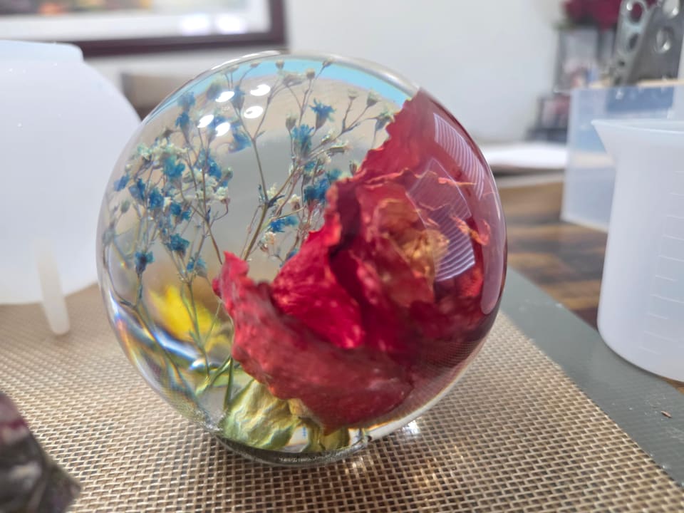 The red rose resin sphere before mounting, seen from the side on a silicone mat