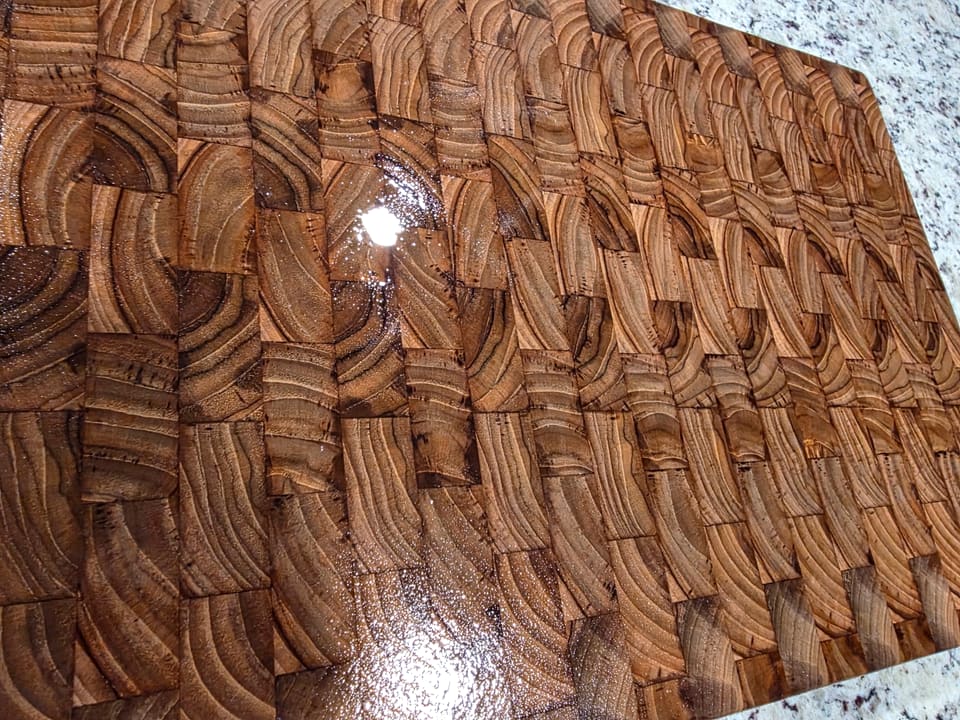 Close view of a glossy end-grain wood surface showing the ring pattern in each block
