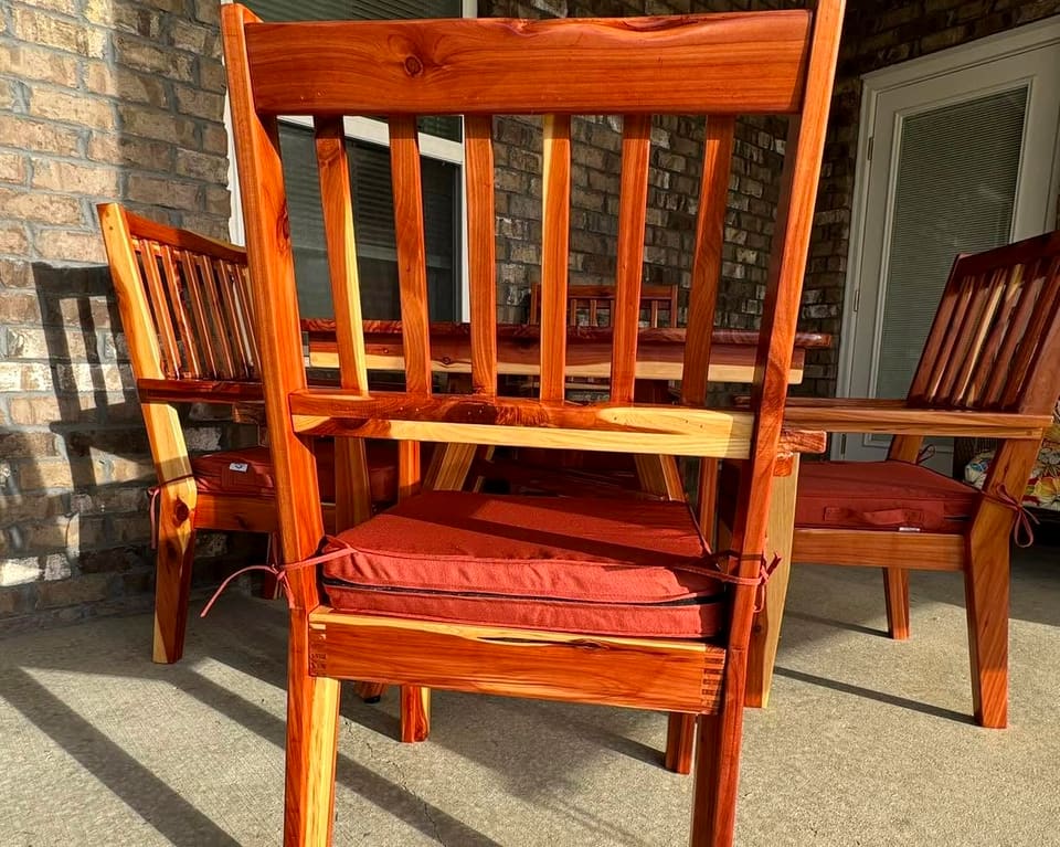 Slat-back armchair with a rust cushion pulled up to the table