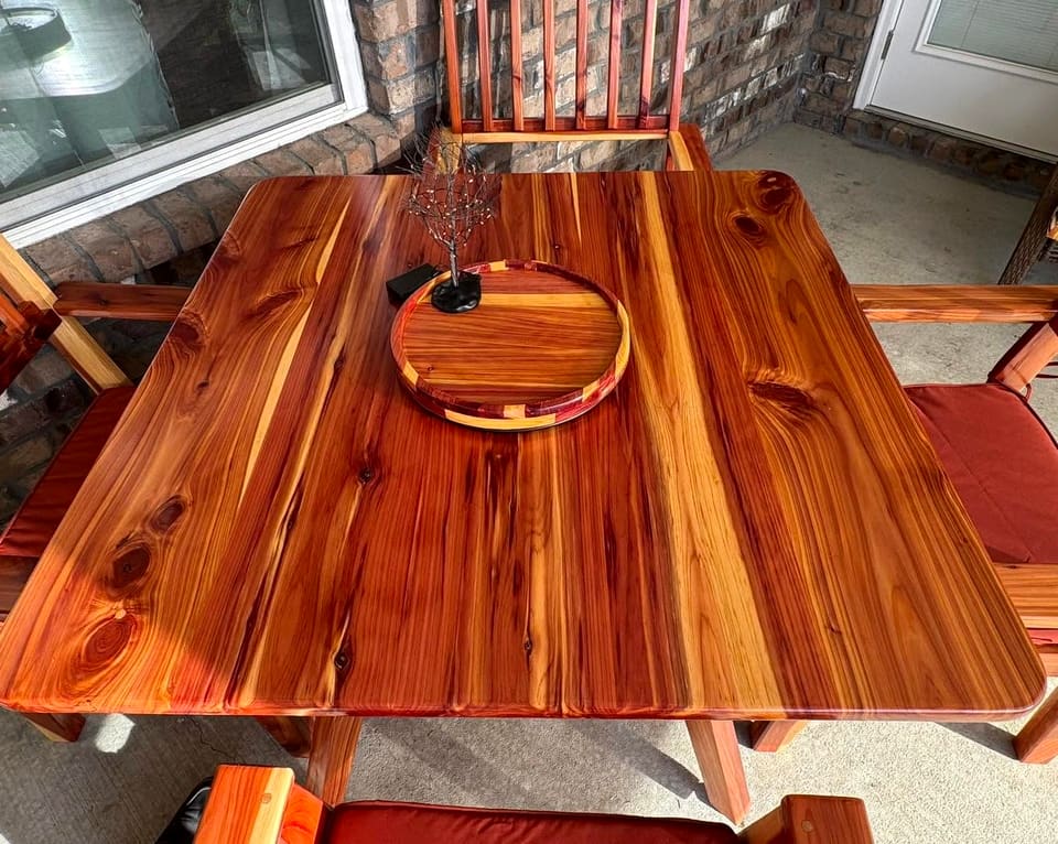 Round banded wood tray with a small metal tree sitting on the tabletop